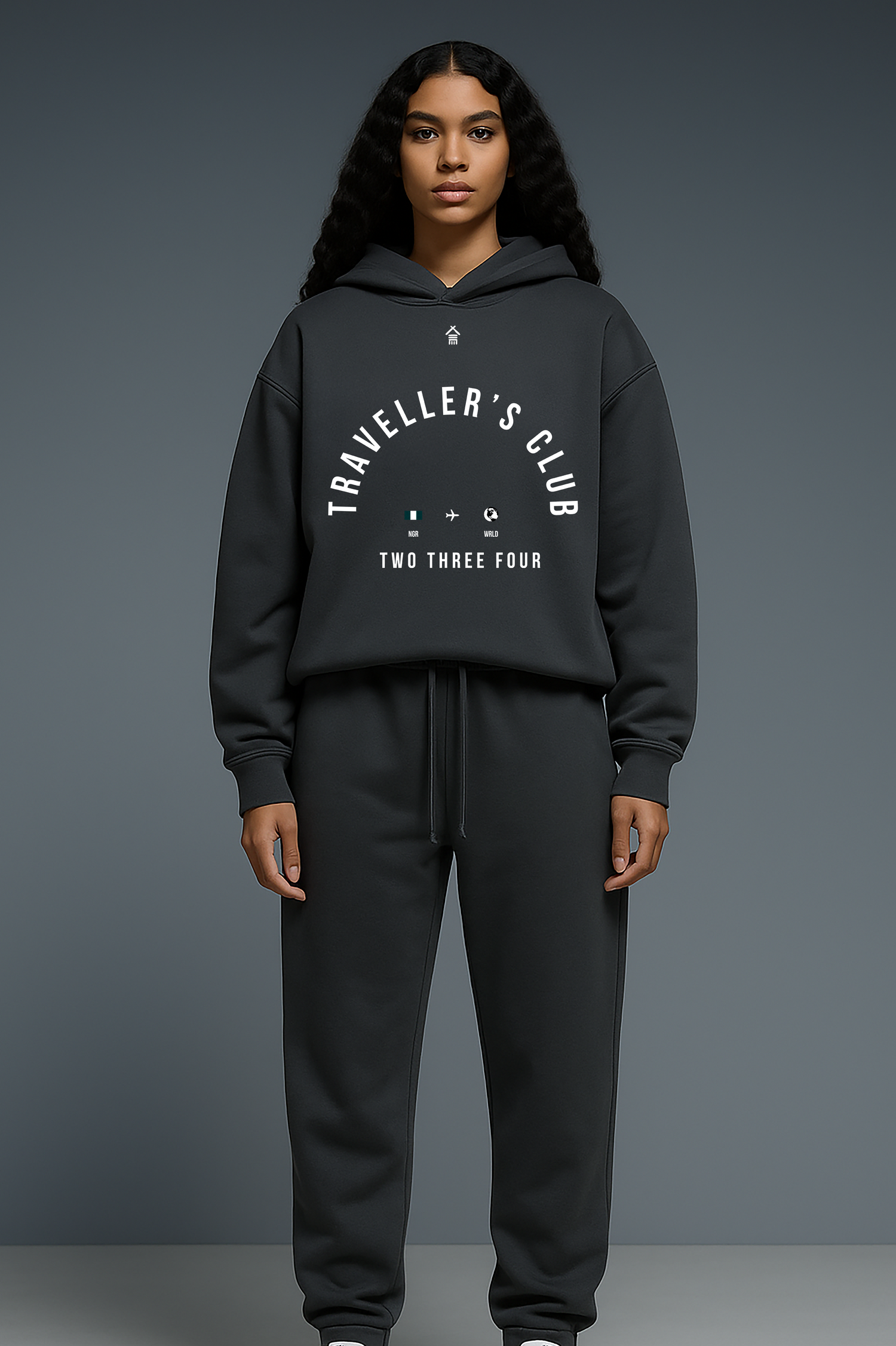 Person wearing a black hoodie and pants with 'Traveller's Club' text on a gray background